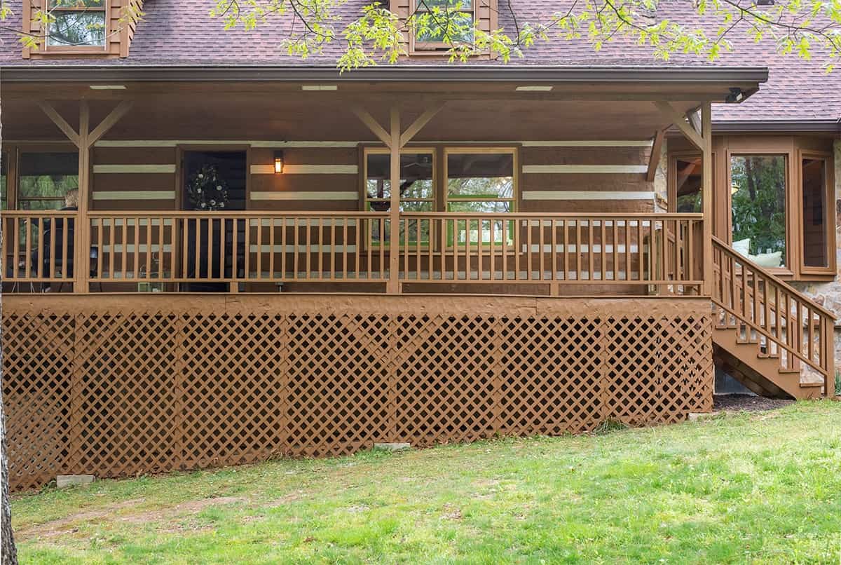 After photo of exterior of Rustic Modern Log home after exterior and lattice was stained with paint sprayer.