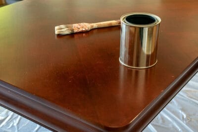 A can of stripper on a table to be refinished.