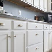 White painted kitchen cabinets with stainless drawer pulls.