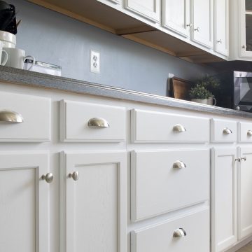 White painted kitchen cabinets with stainless drawer pulls.