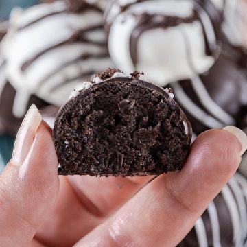Closeup of hand holding oreo ball cross section to show texture.