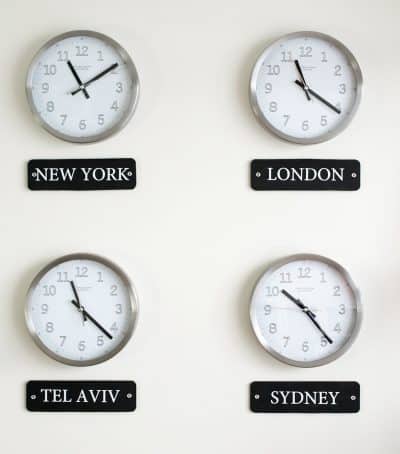 Four clocks with different locations listed below them as a world time zone display.