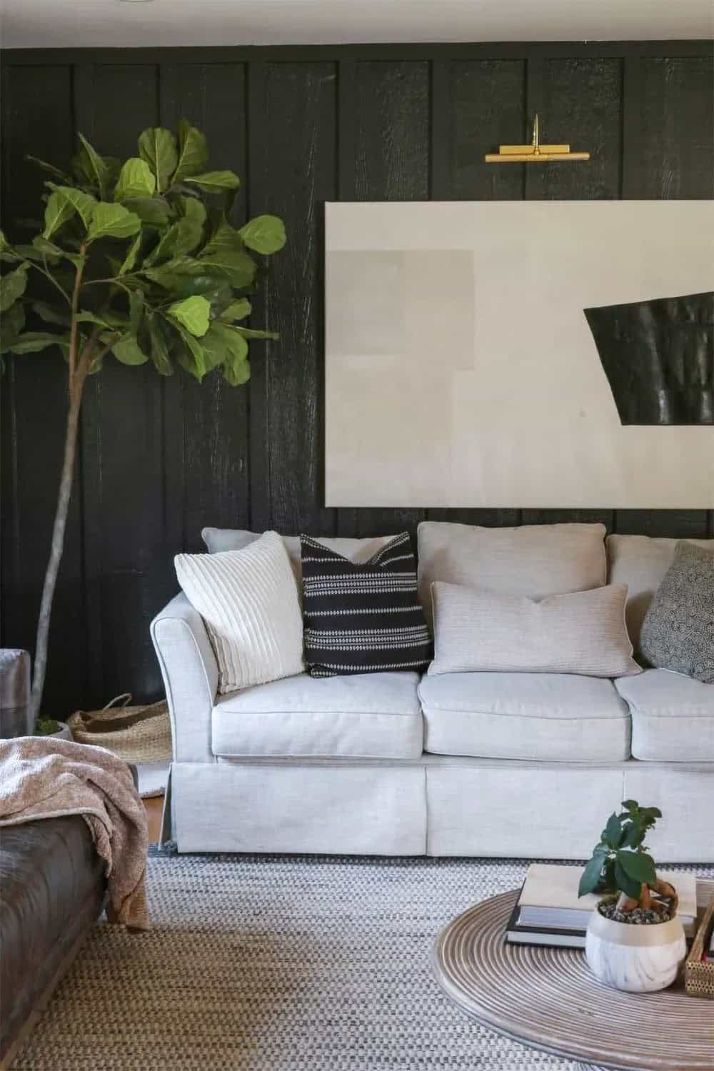 Living room with wood textured walls covered in slats for a black accent wall.