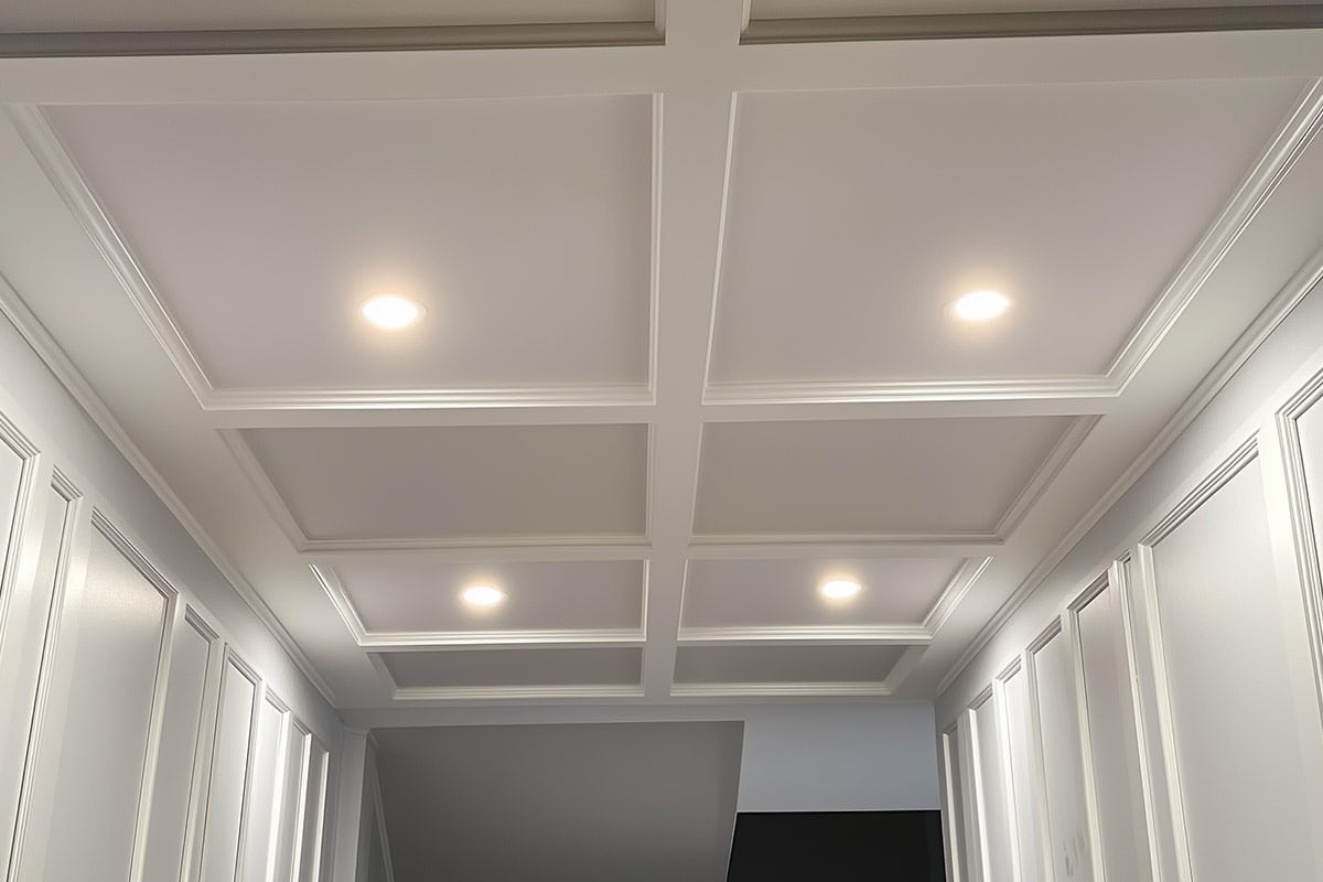 Gray and white coffered ceilings with hidden access in basement ceiling.