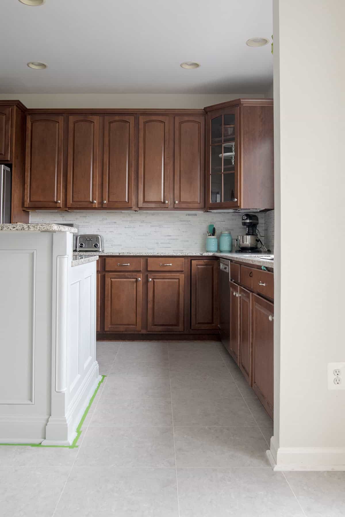 Kitchen with dark wood cabinets and grey vinyl floor tile.