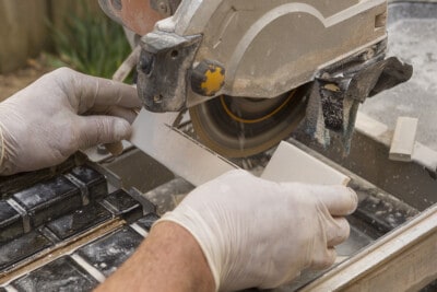Man using a wet saw to cut tile.