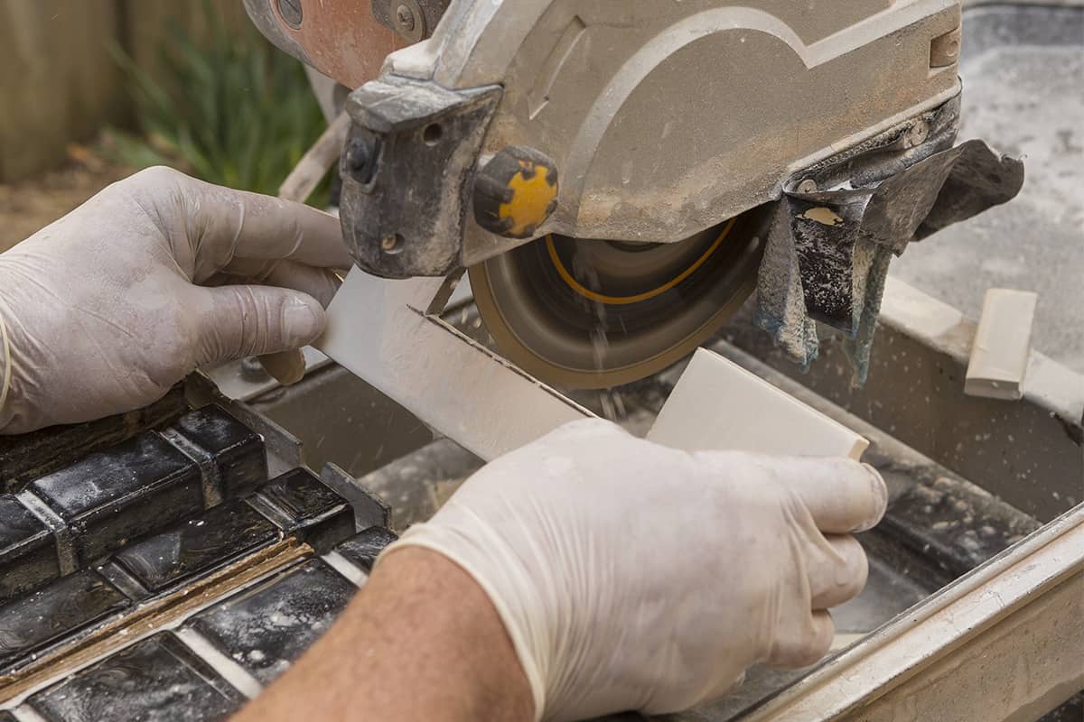 Man using a wet saw to cut tile.