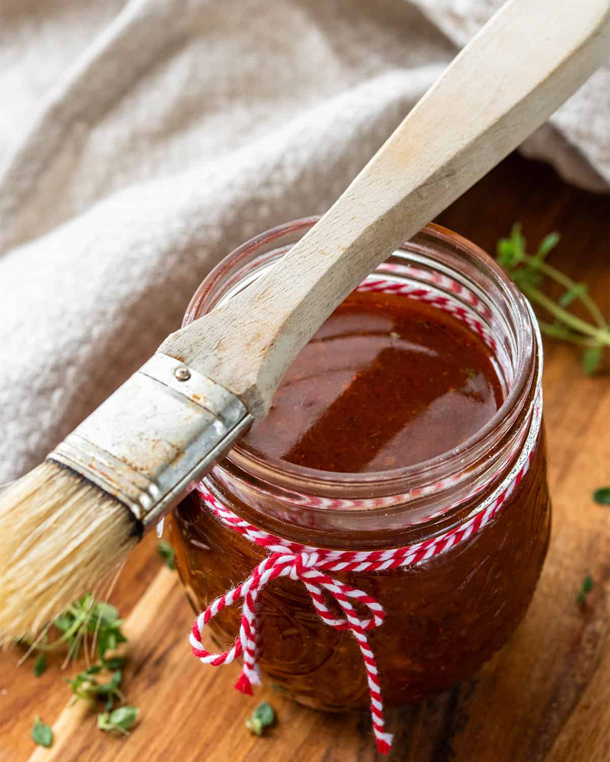 View into a bottle of marinade with a basting brush on top of the jar.
