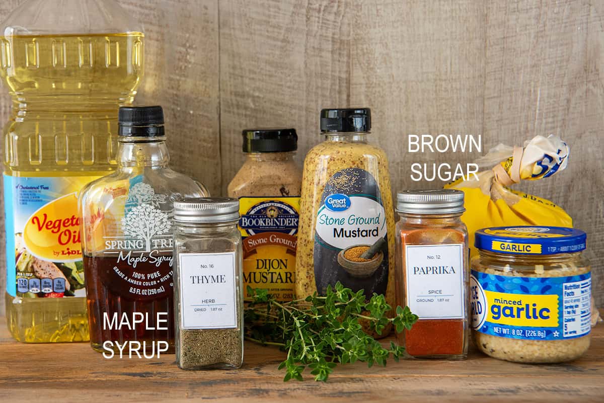 Ingredients to make maple mustard chicken marinade and glaze on a wood table.