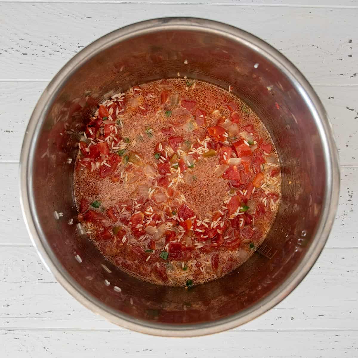 Top-down view of ingredients to make tomato Mexican rice in an instant pot slow cooker.