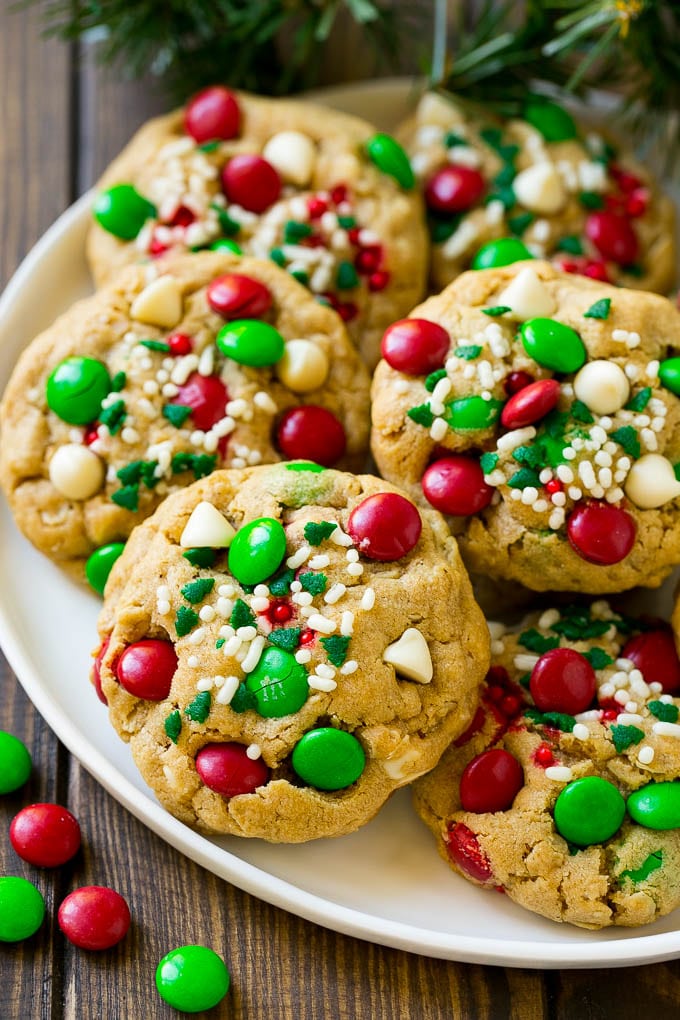 Monster cookies with christmas sprinkles and m&ms on a plate.