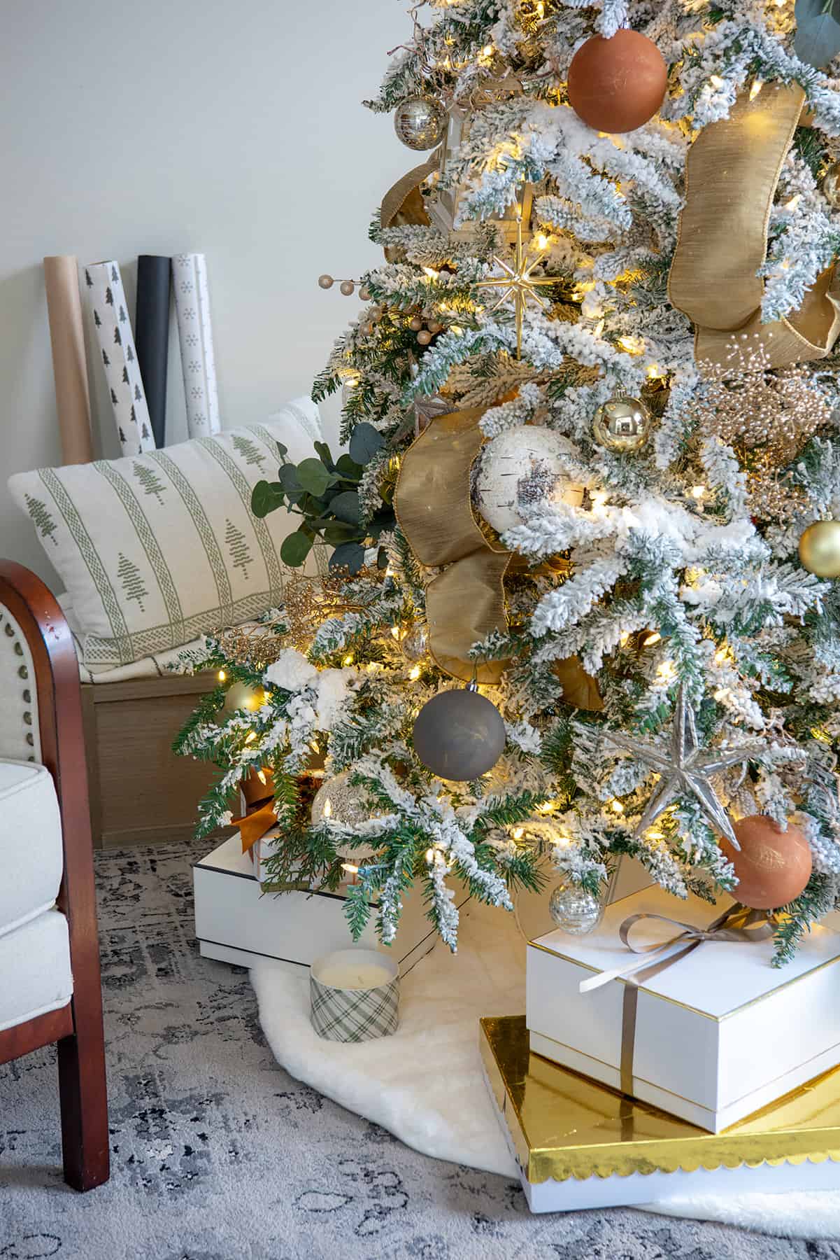 A flocked Christmas tree decorated in natural earth tones and metallic browns with coordinating packages and wrapping paper.