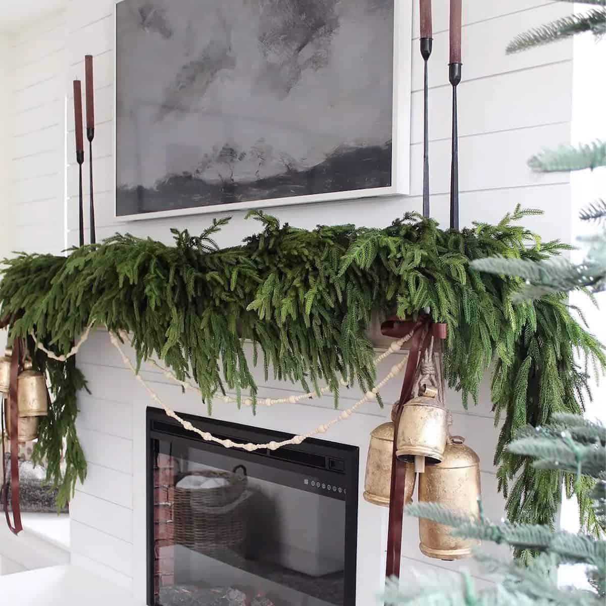 Norfolk pine garland swag over a mantel for Christmas in a minimalist style.