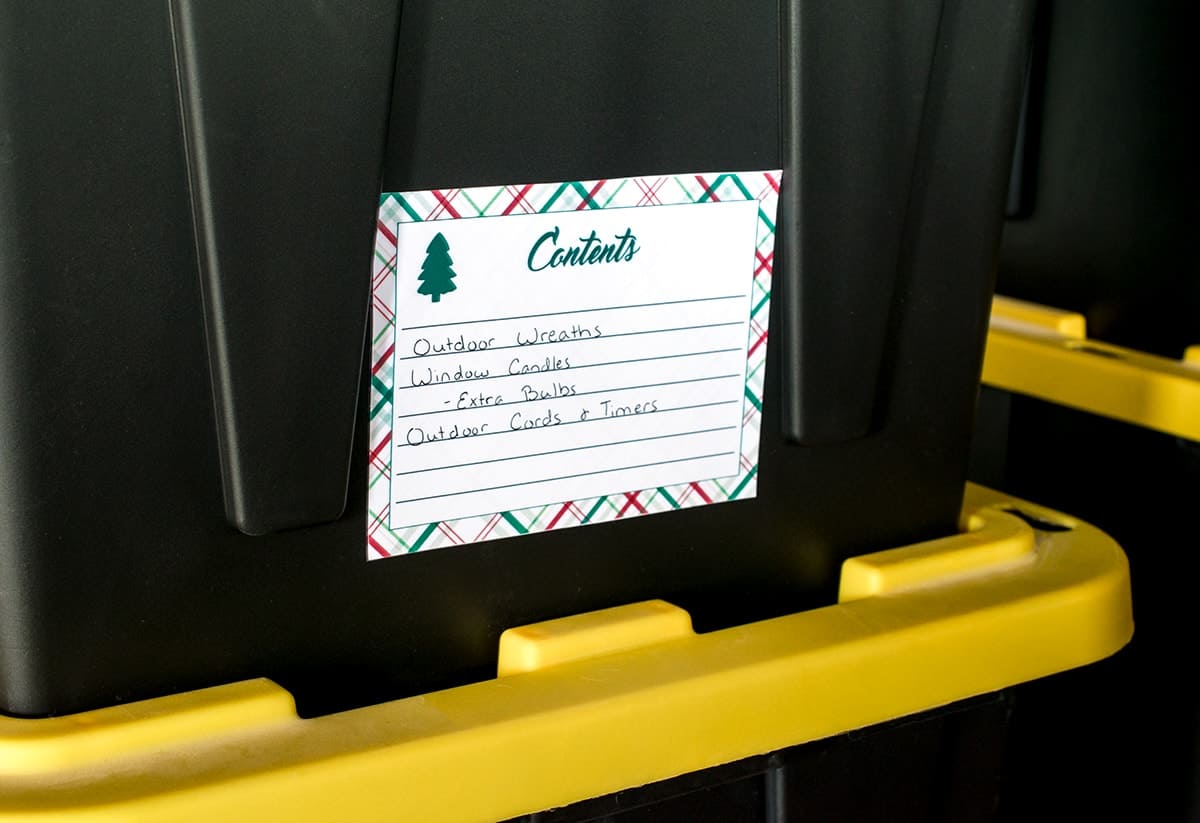 Close up of Christmas storage bin with content label and items listed.