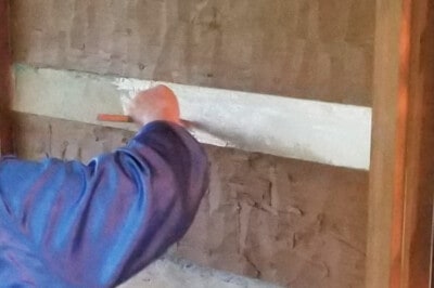 A person painting concrete with a brush.