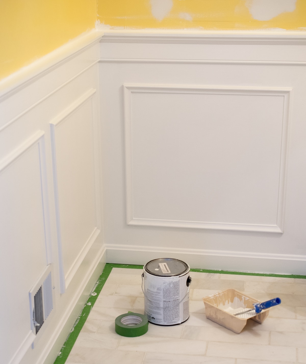 Painting and installing Wainscoting with white paint on the floor.