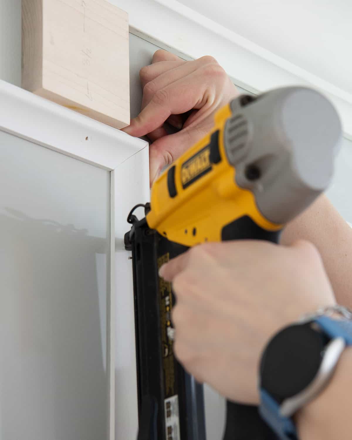 Closeup of pinching a picture frame wainscotting box together for fastening.