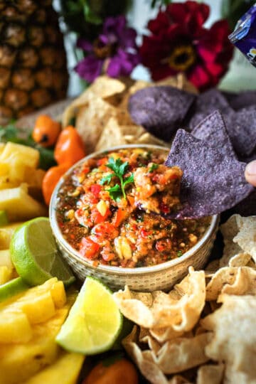 a bowl of spicy habanero pineapple salsa surrounded by tortilla chips.