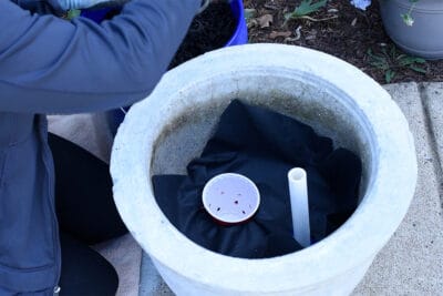 The bottom of a self watering planter without dirt in it.