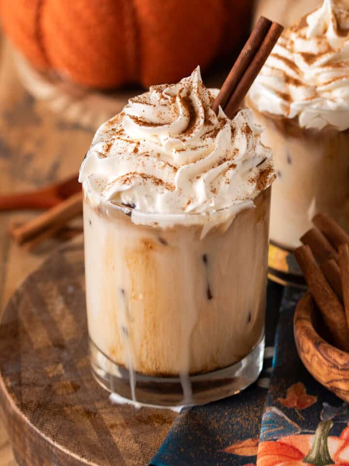 Pumpkin spice white Russian with whipped cream on top and a cinnamon stick.