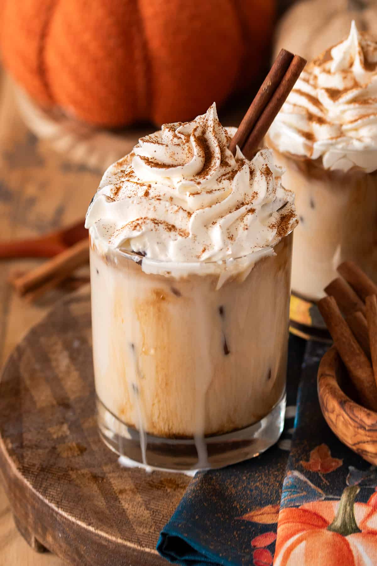 Pumpkin spice white Russian with whipped cream on top and a cinnamon stick.