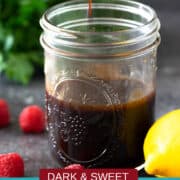 Raspberry Vinaigrette dressing in a jar with a spoon above containing dressing dripping.