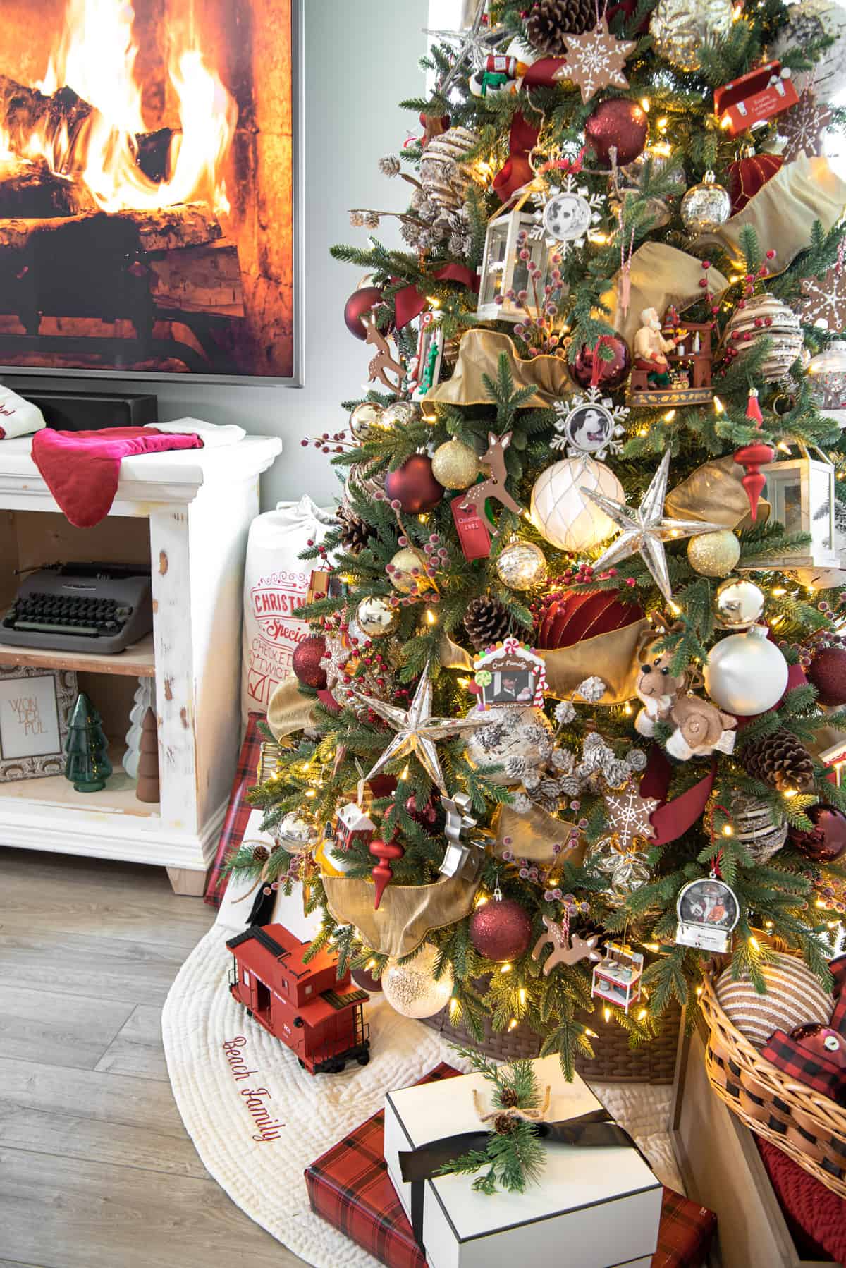Gold Christmas tree with hints of burgundy ornaments and a personalized tree skirt.