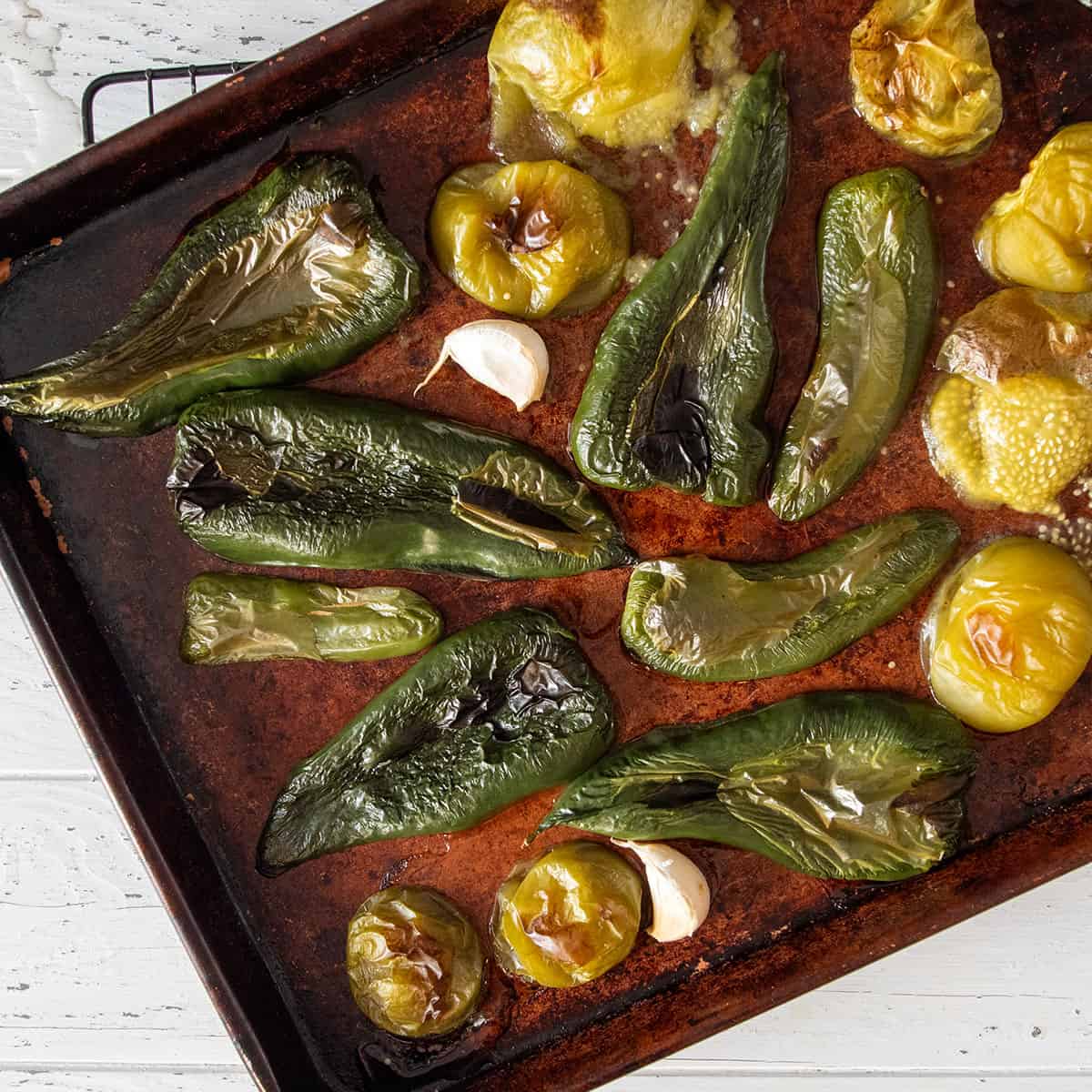 A sheet pan of peppers, garlic, and tomatillos after roasting in the oven.
