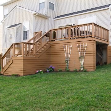 Solid color stained raised deck with shed area underneath.