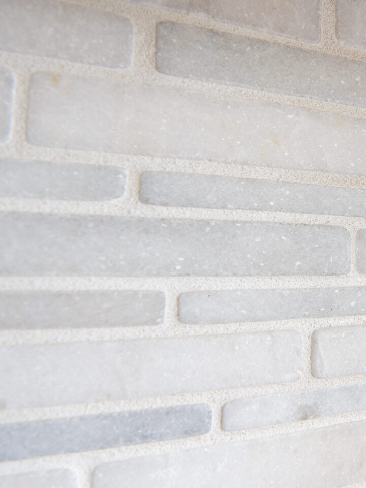 A closeup of sanded grout in honed marble backsplash.