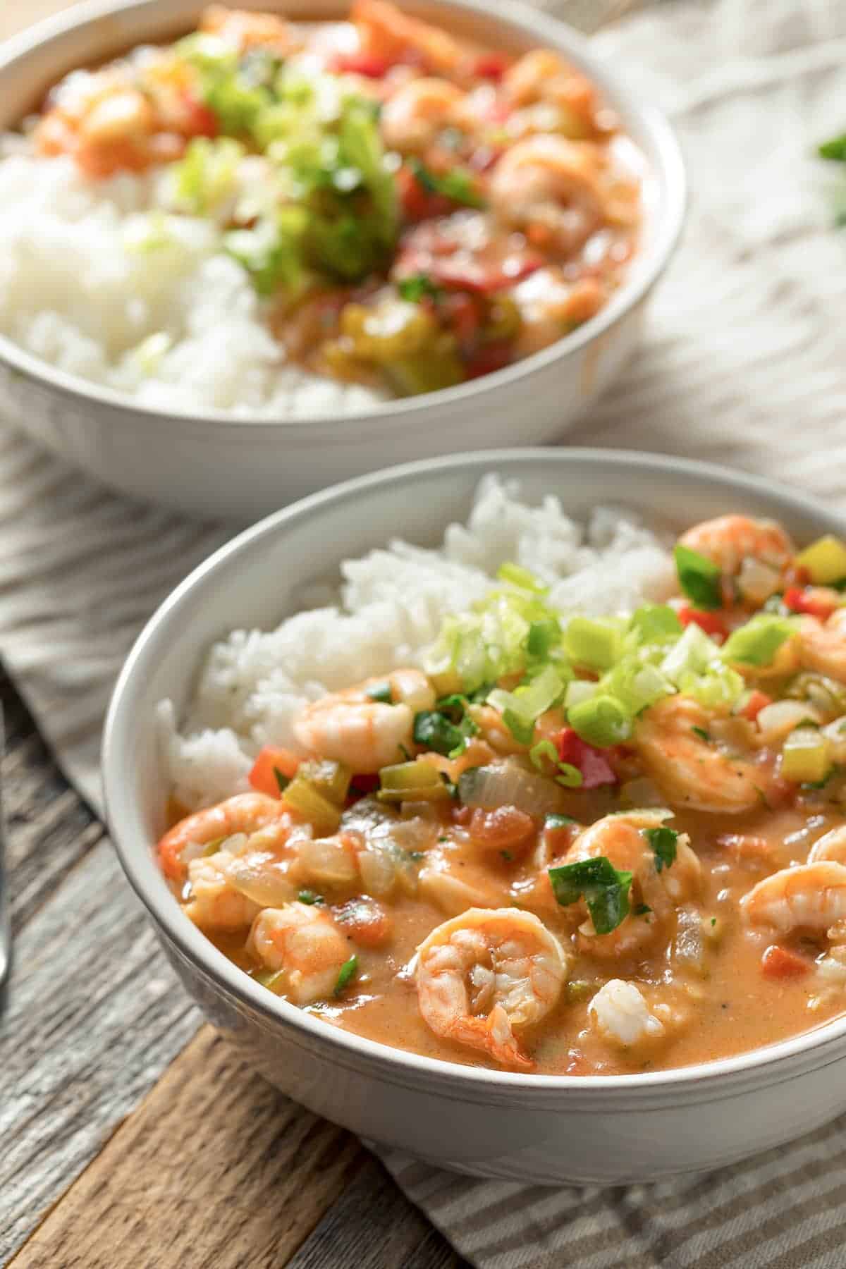 Two generous bowls of Cajun Shrimp Étouffée served over white rice with sliced green onions.