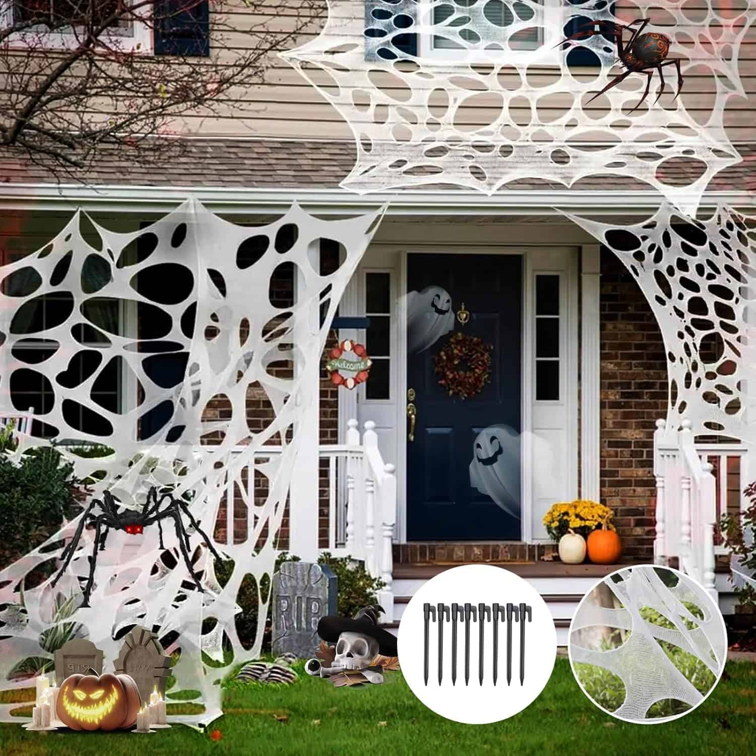 A house covered in gauze spider webs with other Halloween decorations on them.