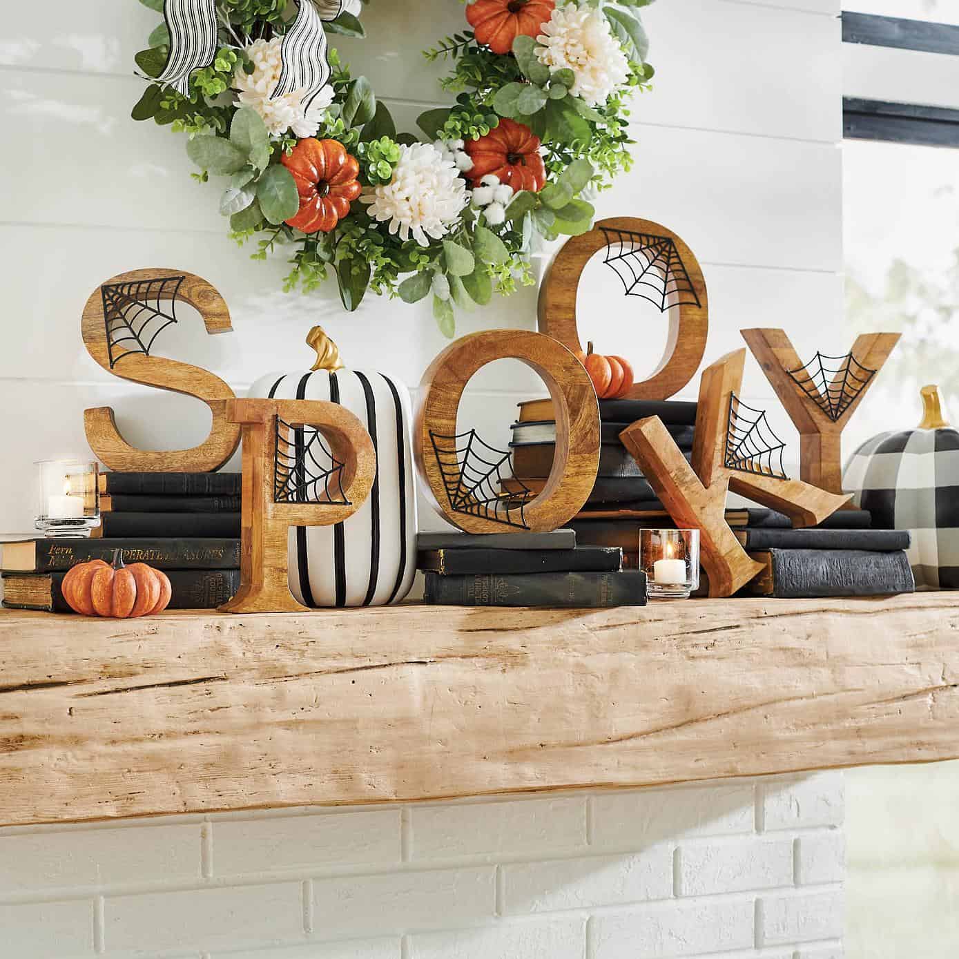 Wooden SPOOKY letters with cobwebs, black antique books, orange pumpkins, and black & white pumpkins.