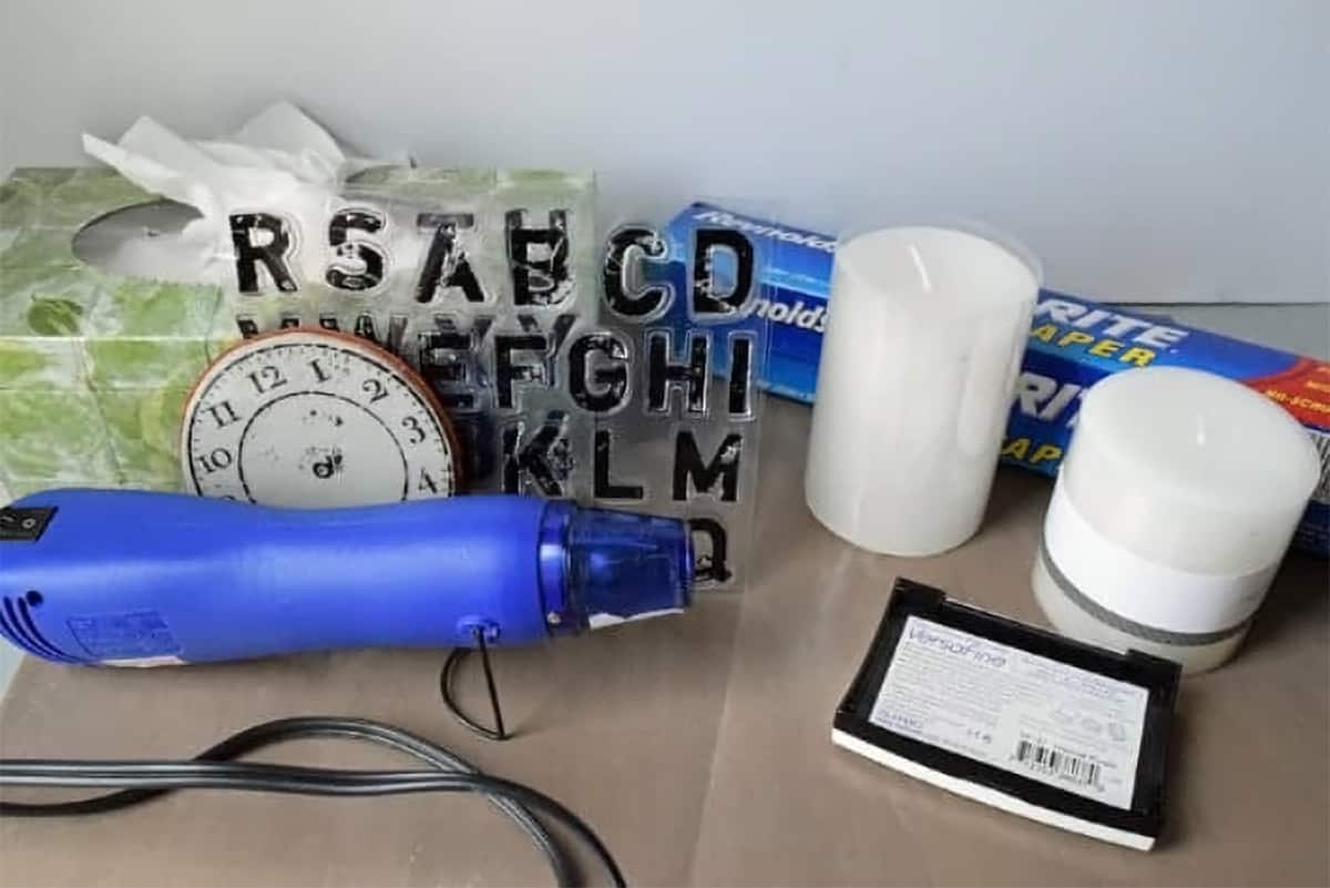 Supplies for stamping candles including stamps, tissue, and heat gun.