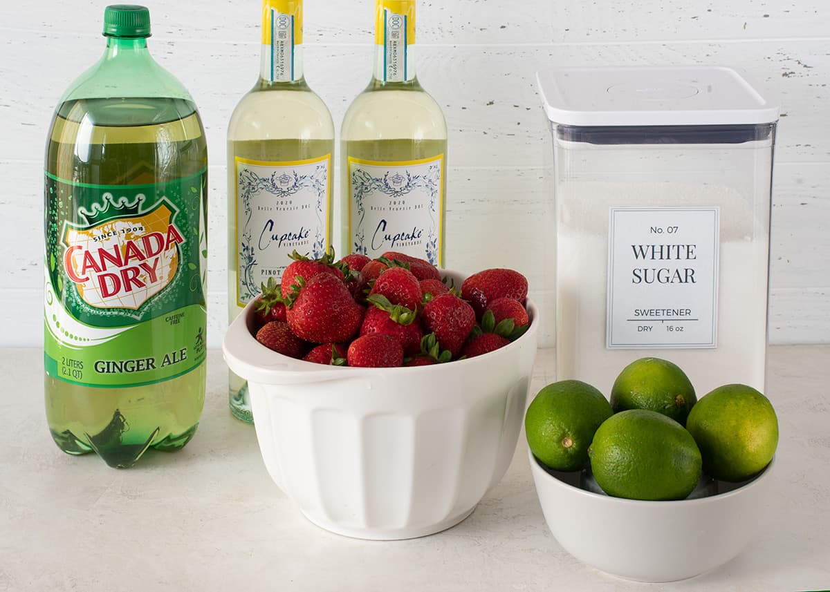 Ingredients for strawberry sangria laid out on a table.