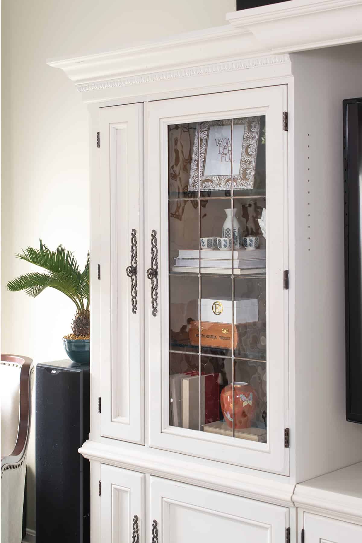 painted white entertainment center with bookshelves with leaded glass doors