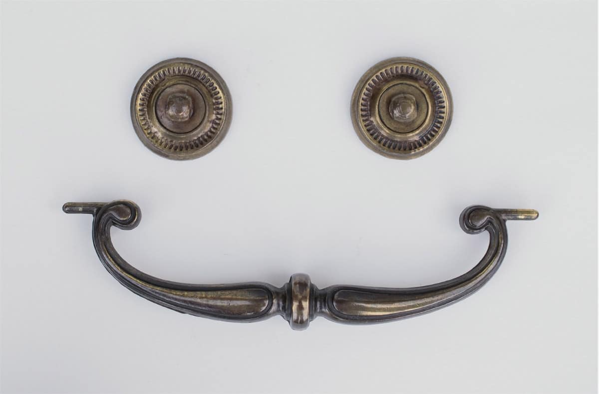 Tarnished brass hardware removed from old desk before cleaning.