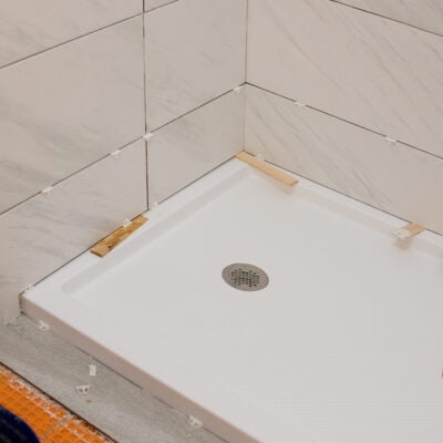 Shower pan being tiled with spacers inserted.