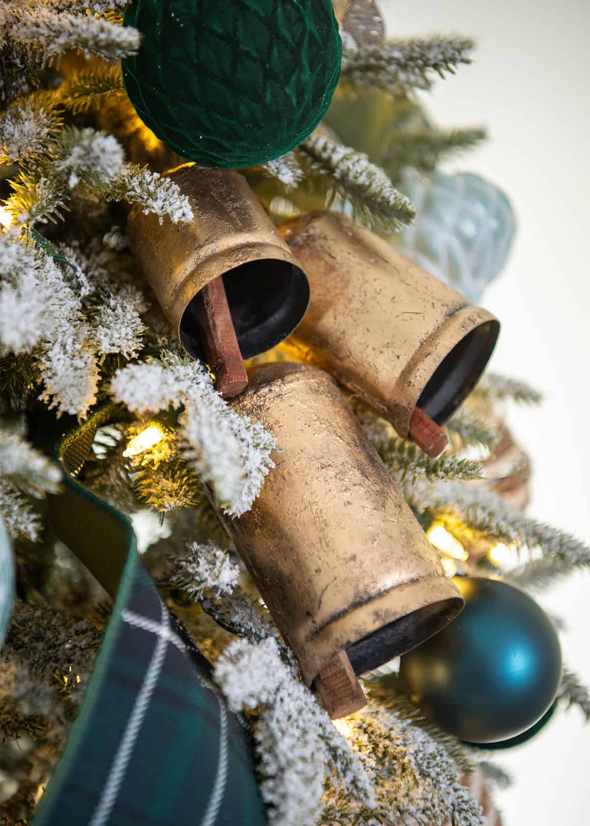 Antique Brass bell ornaments grouped together on a Christmas tree.