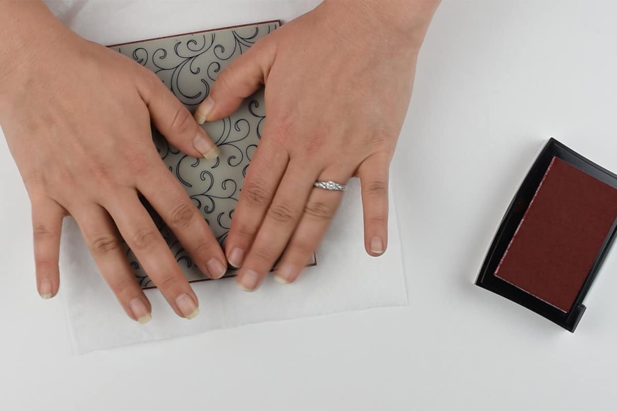 A patterned rubber stamp transposes an image onto a single ply of tissue paper with a pigment based ink.