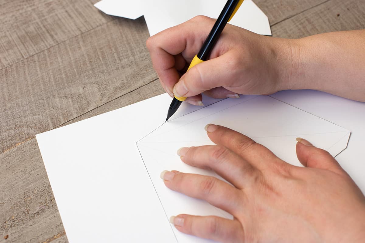 Tracing a star template on a sheet of paper.