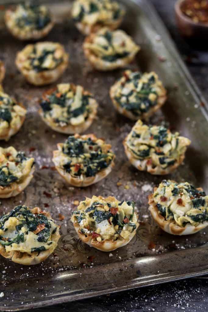 Vegan Spinach Artichoke Phyllo cup appetizer filled with spinach, artichokes, and vegan cheese alternatives.