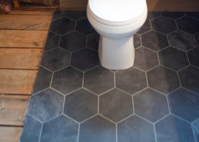 Closeup of vinyl peel and stick hexagon tile installation.