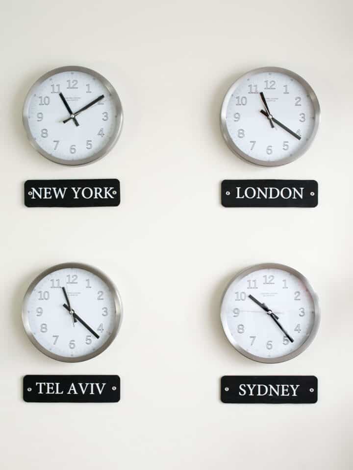 Four clocks with different locations listed below them as a world time zone display.