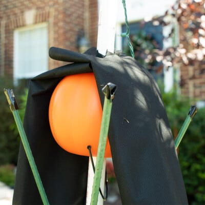 Plastic pumpkin craft with yard fabric over top to form arms.