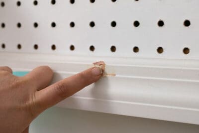 Using wood filler to fill a hole in wood.