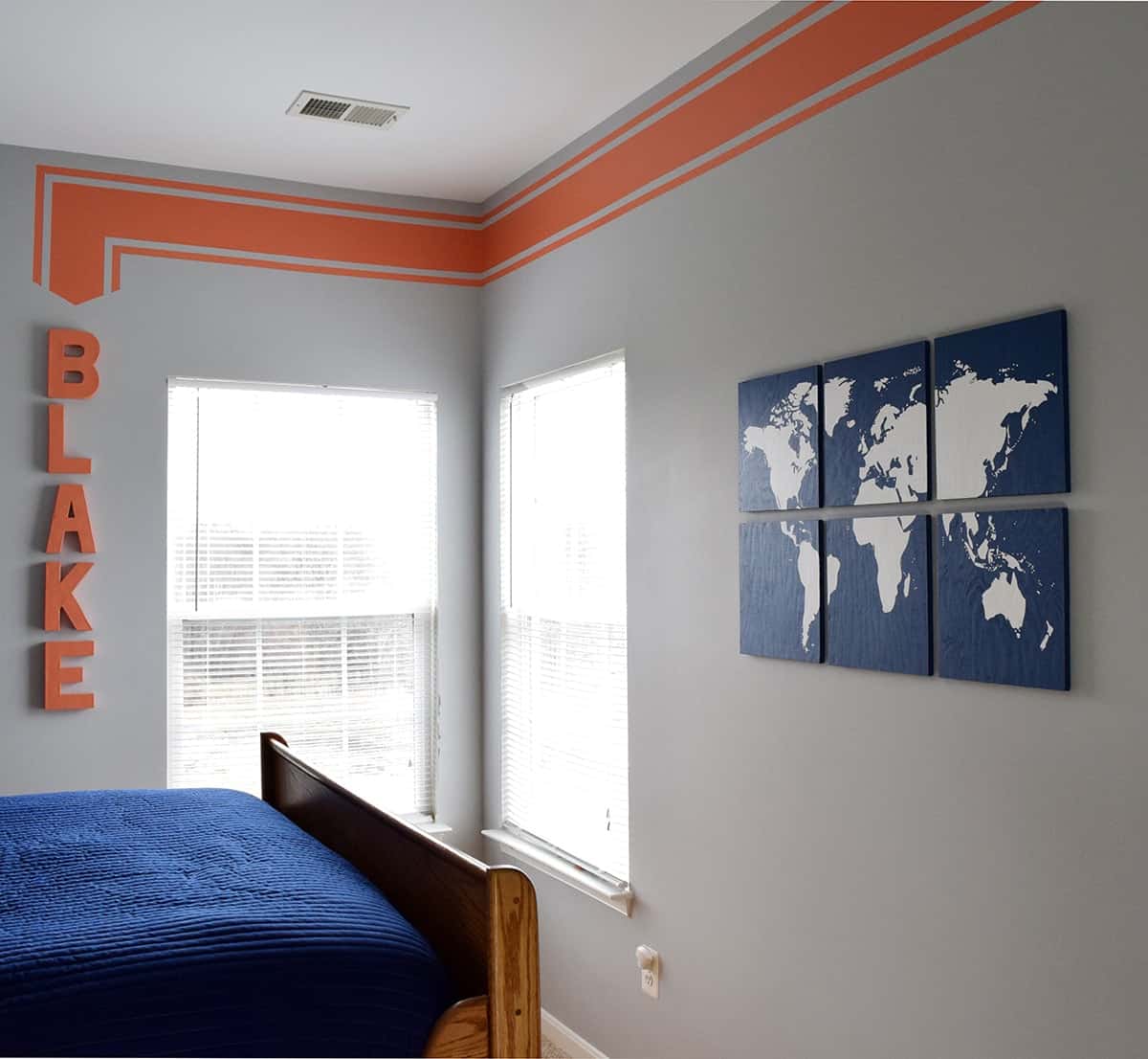 DIY blue and white sectioned world map art on gray wall in boy's room.