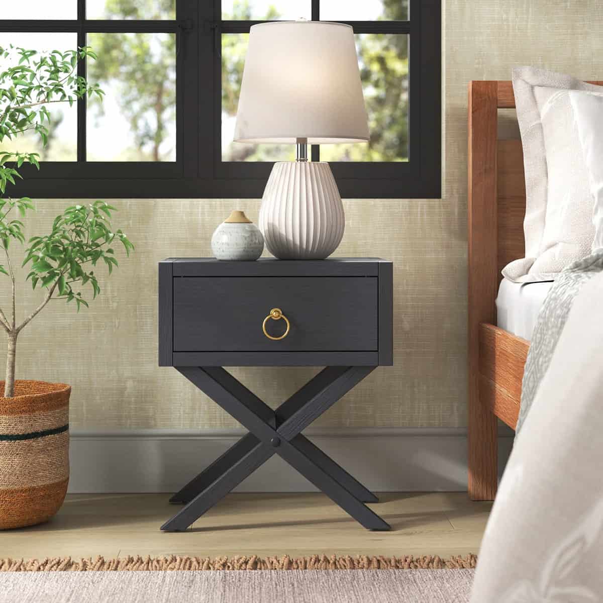 Modern navy nightstand with one drawer and X crisscross metal base in airy bedroom.