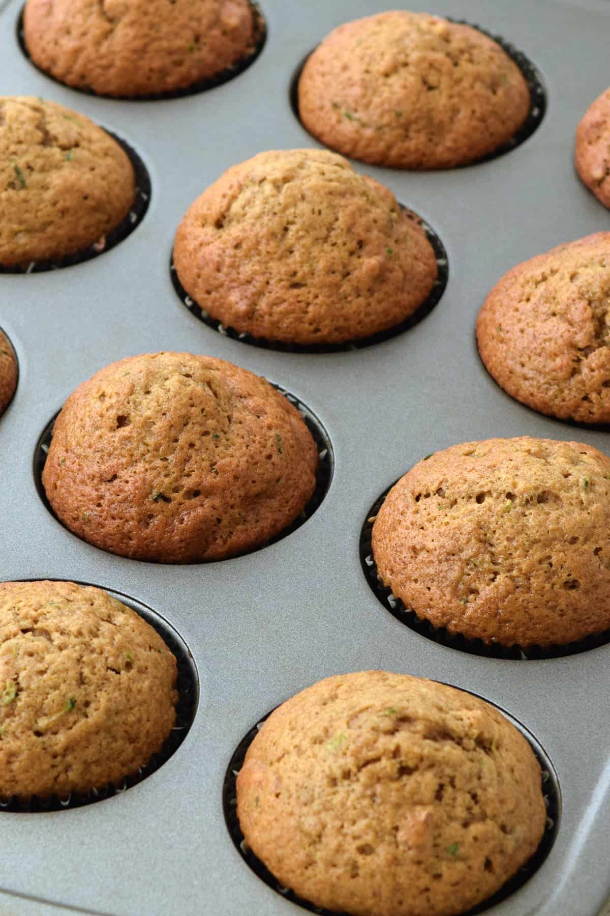 Baked healthy zucchini muffins in a muffin pans.