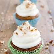 Three cupcakes with homemade cream cheese frosting and sprinkled with nuts.